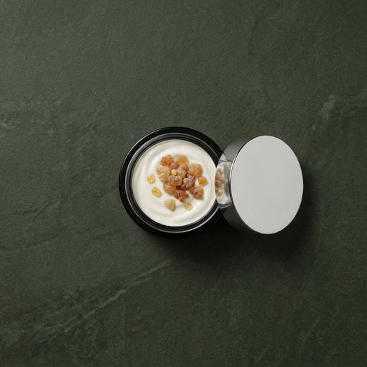 Pot de crème tonifiante vu de dessus, crème blanche avec grains ambrés.