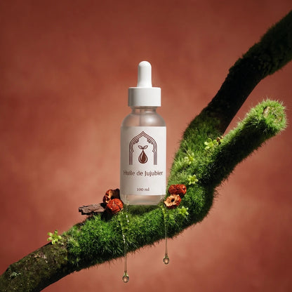 Petit flacon d’huile de jujubier sur branche couverte de mousse, pipette blanche.