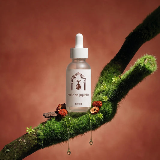 Petit flacon d’huile de jujubier sur branche couverte de mousse, pipette blanche.