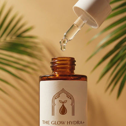 Flacon The Glow Hydra+ 30 ml avec goutte sortant du compte-gouttes, verre ambré.