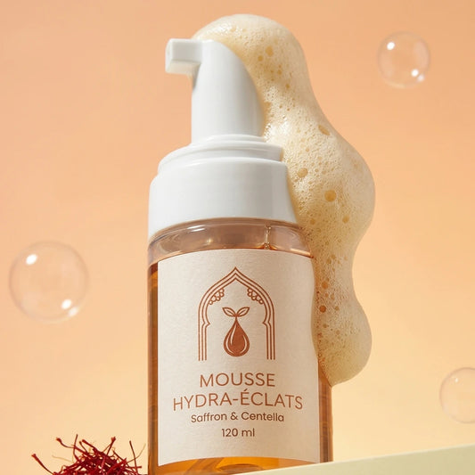 Flacon-pompe mousse hydra-éclats en gros plan, étiquette crème, mousse sur le flacon