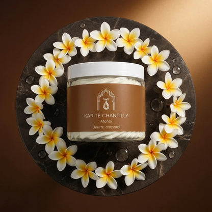 Pot de beurre de karité chantilly au monoï au centre, couvercle blanc, fleurs autour.
