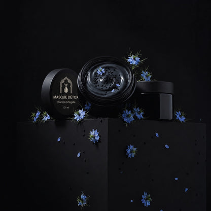 Coffret de masque noir : pots et étuis rectangulaires, fleurs bleues et particules
