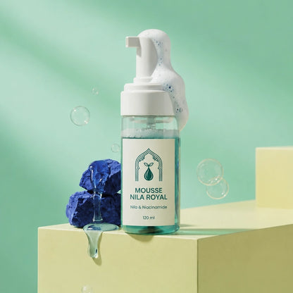 Flacon-pompe de mousse, liquide bleu-vert, bulles autour, pompe blanche