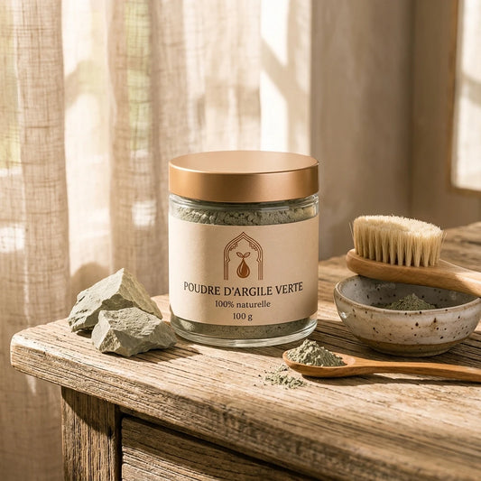 Pot en verre de poudre d’argile verte 100 g, brosse et morceaux de roche à côté.