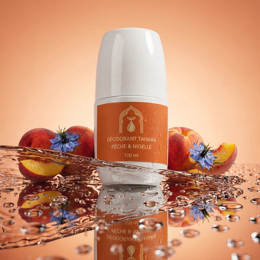 Déodorant en stick blanc, étiquette brune « Pêche & nigelle », avec gouttes autour.
