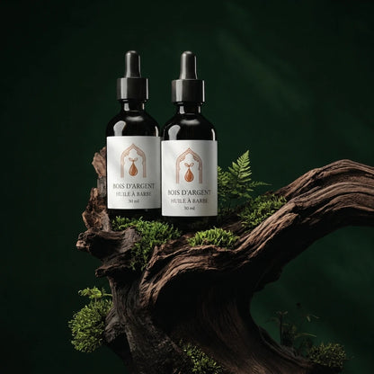 Deux flacons d’huile à barbe, pipettes noires, étiquettes beige, sur racine