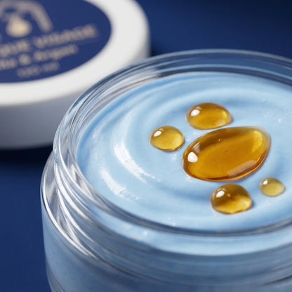 Gel bleu translucide du masque visage dans un pot, avec gouttes d’huile dorées