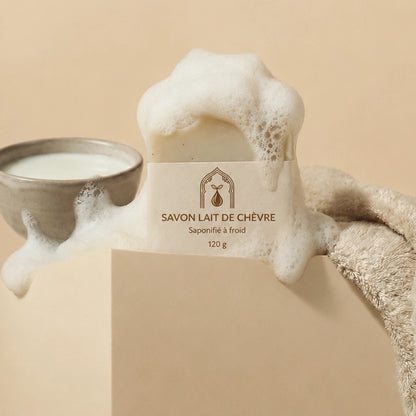 Savon au lait de chèvre blanc en bloc, étiquette crème, mousse autour