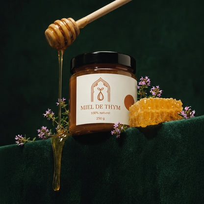 Pot de miel de thym 250 g, filet de miel coulant d’une cuillère en bois et rayon de miel