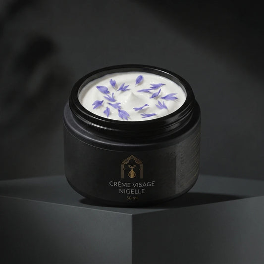 Pot de crème visage à la nigelle noir avec couvercle, crème blanche et fleurs violettes