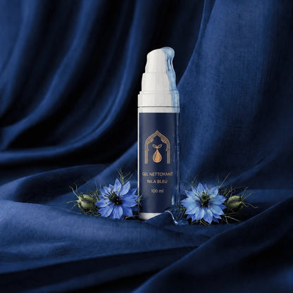 Flacon de gel nettoyant nila bleu avec fleurs bleues, présentation sur tissu.