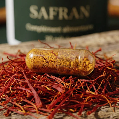 Gélule transparente remplie de poudre jaune de safran, sur des pistils.