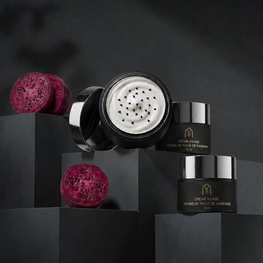 Deux pots de crème visage noirs, couvercles ouverts, crème blanche et graines noires.