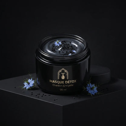 Pot de masque détox noir avec couvercle, étiquette crème et fleurs bleues