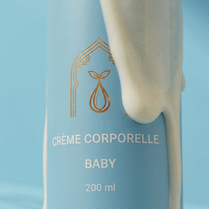 Flacon de crème corporelle Baby : étiquette dorée sur fond bleu, goutte de crème.
