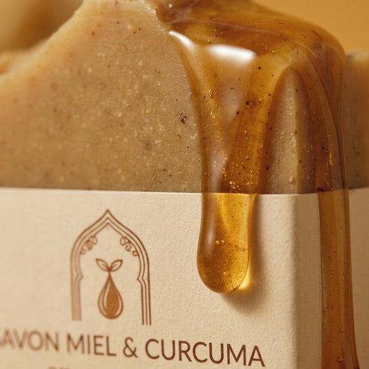 Savon solide miel et curcuma beige, étiquette crème, filet de gel ambré dégoulinant.