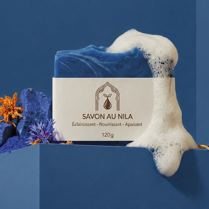 Savon bleu avec mousse blanche et étiquette beige « SAVON AU NILA », 120 g.