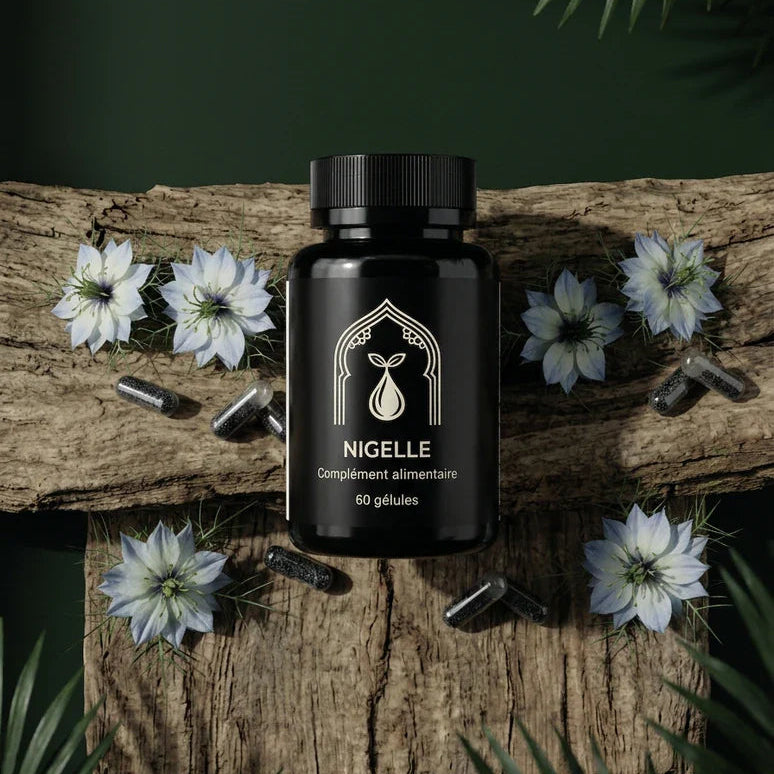 Flacon noir Nigelle 60 gélules sur bois, capsules sombres dispersées et fleurs blanches.