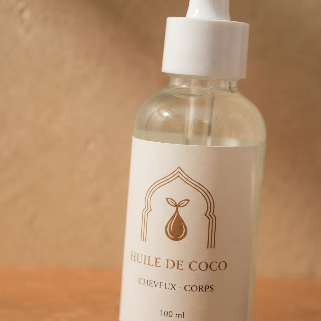 Flacon d’huile de coco transparent 100 ml avec pompe blanche et étiquette crème.