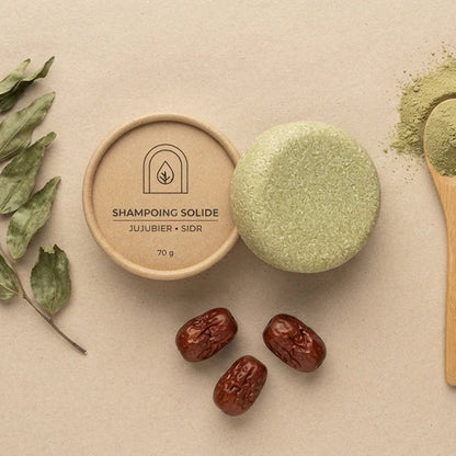 Shampoing solide vert olive, galette à côté et cuillère remplie de poudre